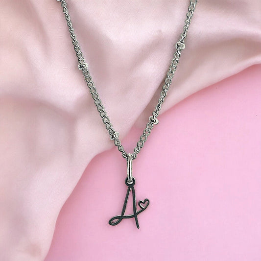 Cursive initial necklace with heart in silver-tone stainless steel, letter A shown – Denoon London