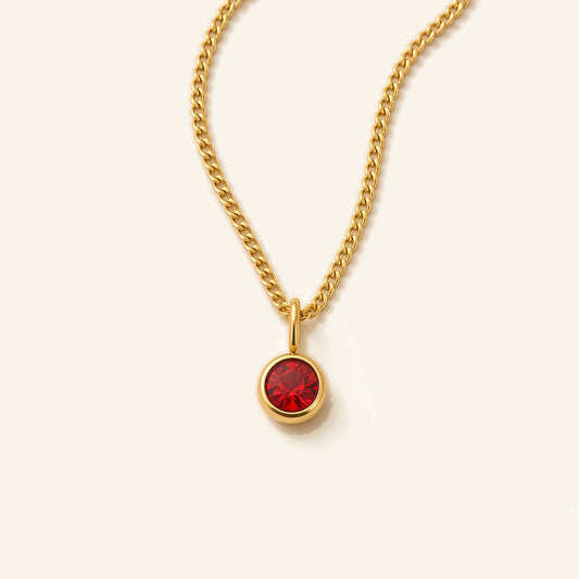 Denoon London Birthstone necklace with crystal birth month pendant in gold-tone, 45cm, flat lay on cream