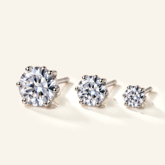 Denoon London solitaire crystal stud earrings, set of three in silver-tone, flat lay on cream