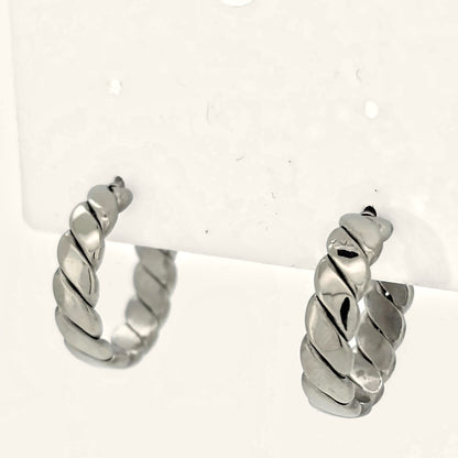 Denoon London chunky twisted hoop earrings, silver-tone, on a display card on cream