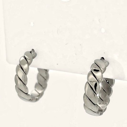 Denoon London chunky twisted hoop earrings, silver-tone, on a display card on cream