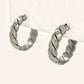 Denoon London chunky twisted hoop earrings, silver-tone, close-up side view on cream