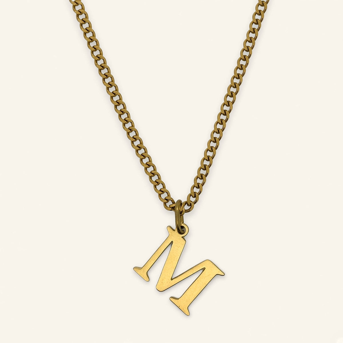 Denoon London Classic Initial necklace, gold-tone letter M, on cream
