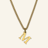Denoon London Classic Initial necklace, gold-tone letter M, on cream