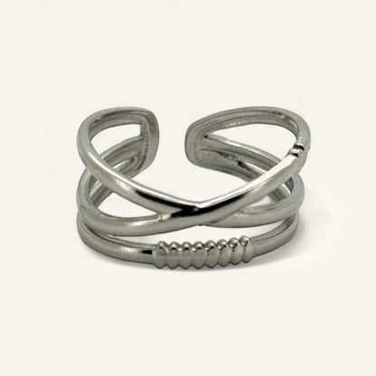 Denoon London crossover statement ring, silver-tone, on a cream background