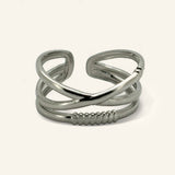 Denoon London crossover statement ring, silver-tone, on a cream background