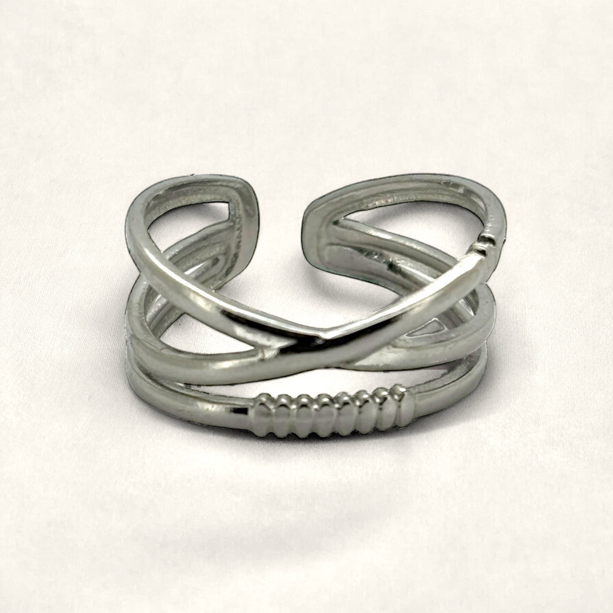 Denoon London crossover statement ring, silver-tone, styled on cream