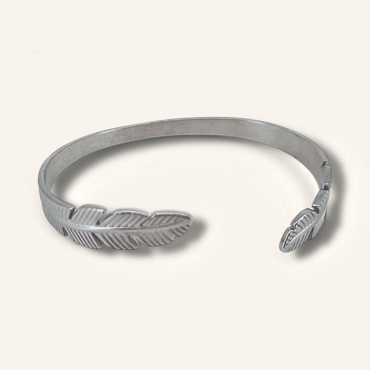 Denoon London double feather adjustable bangle, silver-tone, on a cream background