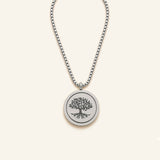 Denoon London Serenity Prayer necklace with Tree of Life spinning pendant in silver-tone, flat lay on cream