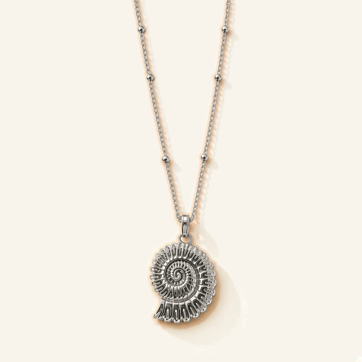 Denoon London shell pendant necklace in silver-tone, flat lay