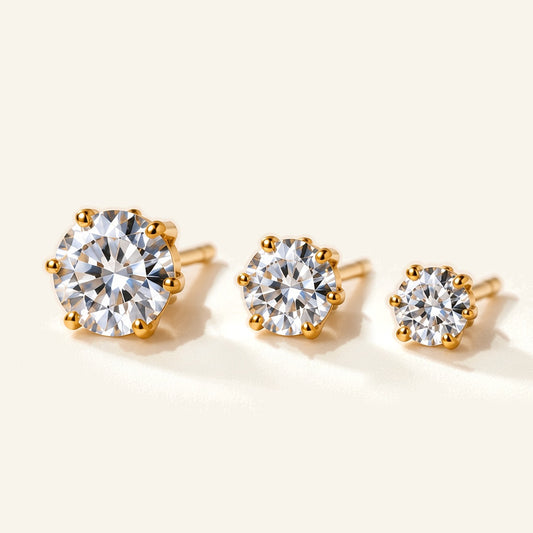 Denoon London Solitaire Crystal Stud Earrings Set of 3 in gold-tone, 6mm, 5mm and 4mm, flat lay on cream